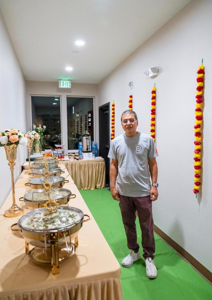 A Yogiplate catering buffet with gold chafing dishes and marigold garlands